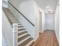 Bright and airy staircase featuring hardwood steps, a white railing, and a modern aesthetic at 175 Darby Meadow Ln, Ridgeville, SC 29472