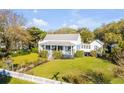 Beautiful home with well-manicured lawn, picket fence, and blooming roses; ideal for outdoor enjoyment at 1808 Ion Ave, Sullivans Island, SC 29482