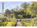 Inviting front yard with mature trees, lush greenery, and a charming picket fence leading to the property at 1808 Ion Ave, Sullivans Island, SC 29482