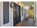 Charming porch with decorative front door, welcome mat, lanterns, and rocking chair at 2041 Ashburton Way, Mount Pleasant, SC 29466