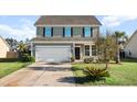 Charming two-story home with siding, a driveway, an attached two car garage, and a well-maintained front lawn at 2150 Pimlico Dr, Ridgeville, SC 29472