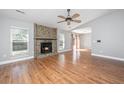 Bright living room with hardwood floors, a cozy stone fireplace, and a ceiling fan at 2306 Chairmaker Ct, Charleston, SC 29414