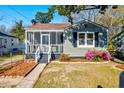 Charming home featuring a screened-in porch and beautifully landscaped front yard with colorful flowers at 2314 Kent Ave, North Charleston, SC 29405
