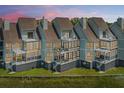 A charming row of townhomes with expansive windows and private balconies at 242 Little Oak Dr, Folly Beach, SC 29439