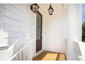 Inviting entryway featuring a wooden door, stylish lanterns, and white painted trim at 3105 Vanessa Lynne, Johns Island, SC 29455