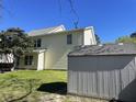 Backyard view of a two-story home, grass lawn, storage building and landscaping at 329 Carriage Wheel Rd, Moncks Corner, SC 29461
