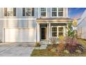 Close-up of light-blue home's front entrance, flower bed, and two-car garage at 462 Fox Sparrow Ct, Summerville, SC 29486