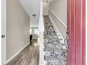 Warm entryway with decorative carpet on the stairs and durable laminate flooring in the hall at 4852 Rocking Porch Ln, Summerville, SC 29485