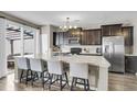 Eat-in kitchen with an island breakfast bar featuring stainless steel appliances and dark wood cabinets at 4852 Rocking Porch Ln, Summerville, SC 29485