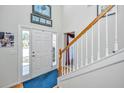 Bright foyer featuring hardwood floors, a staircase, and a front door with decorative glass at 9408 Harroway Rd, Summerville, SC 29485