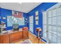Office with bright blue walls, hardwood floors, desk, and large windows at 9408 Harroway Rd, Summerville, SC 29485