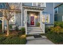 View of the front porch with a bright red door, white trim, and neat landscaping at 107 Nutmeg Way, Summerville, SC 29485