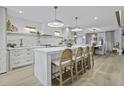 Open kitchen featuring a large island with barstool seating, marble backsplash, and pendant lighting at 1103 Ventura Pl, Mount Pleasant, SC 29464