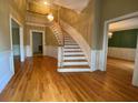 Grand foyer with hardwood floors, curved staircase, chandelier, and decorative trim, creating an elegant entry at 116 W Johnston St, Summerville, SC 29483