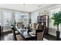 Bright dining room with large windows, elegant chandelier, and dark wood table at 123 Hewitt St, Summerville, SC 29486