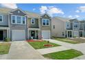 Exterior view of attractive townhomes with attached garages, well-kept lawns and landscaping at 124 Gaura Ln, Summerville, SC 29483