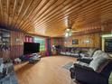 Spacious living room with wood-paneled walls and ceiling, plush seating, and a ceiling fan at 1393 Russellville Rd, Saint Stephen, SC 29479