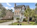 Beautiful two-story home showcasing a well-manicured lawn and a charming entrance with a white picket fence at 1428 Bloomingdale Ln, Mount Pleasant, SC 29466