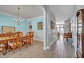 Elegant dining room with chandelier, wood floors, and calming color scheme with an adjacent hallway at 144 Back Tee Cir, Summerville, SC 29485