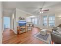 Bright and airy living room with hardwood floors, ceiling fan, and a partial view into the kitchen at 1822 Chatelain Way, Mount Pleasant, SC 29464
