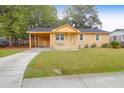 Charming single story home with a well-manicured lawn and a covered parking area on a sunny day at 1873 Hazelwood Dr, Charleston, SC 29407