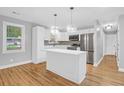 Modern kitchen features white cabinets, stainless steel appliances, kitchen island and stylish pendant lighting at 1873 Hazelwood Dr, Charleston, SC 29407