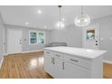 Bright, open kitchen features white cabinets, a large island, and stylish pendant lighting, with a view to a living area at 1873 Hazelwood Dr, Charleston, SC 29407