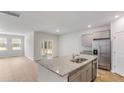 Open kitchen featuring stainless steel appliances, large island, and access to the backyard at 2275 Macallan Blvd, Ravenel, SC 29470