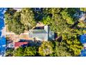Birds eye view of home with green roof surrounded by mature trees and red garage at 2314 Goldbug Ave, Sullivans Island, SC 29482