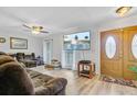 Cozy living room featuring wood floors, a ceiling fan, a large TV, and a comfortable reclining sofa at 276 S Railroad Ave, Harleyville, SC 29448