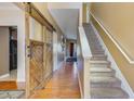 Inviting foyer featuring hardwood floors, a staircase, and a rustic sliding barn door at 3016 Adventure Way, Ladson, SC 29456