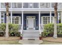 Inviting front door with white trim, potted flowers, and steps leading up to the entrance at 3409 Southern Cottage Way, Mount Pleasant, SC 29466