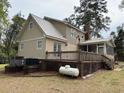 Side view of house showing metal roof, rear deck, covered porch, and brick foundation at 4 Fairway Ct, Walterboro, SC 29488
