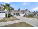 Beautiful one-story home features a 2-car garage, a cozy front porch, and mature landscaping at 458 Four Seasons Blvd, Summerville, SC 29486