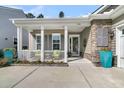 Inviting front porch with seating, plants, and stone accents creating a warm welcome to the home at 458 Four Seasons Blvd, Summerville, SC 29486