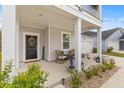Charming front porch features a cozy seating area and stylish door with a wreath at 68 Red Bluff St, Summerville, SC 29483