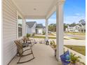 Inviting front porch with rocking chairs, perfect for relaxing and enjoying the neighborhood view at 68 Red Bluff St, Summerville, SC 29483