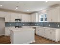 Modern kitchen boasts white cabinetry, stainless steel appliances, and stylish tile backsplash at 8703 Forte Dr, North Charleston, SC 29406