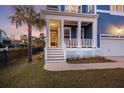 Inviting covered front porch with white columns, wood stairs, and a storm door at 1251 Weather Helm Dr, Mount Pleasant, SC 29466