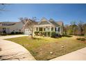 Charming single-story home featuring a manicured lawn, inviting front porch, and lush landscaping at 126 Citrea Dr, Summerville, SC 29483