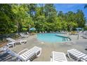 Community pool surrounded by lounge chairs and lush greenery on a sunny day at 164 Buchanan Cir, Goose Creek, SC 29445