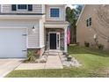 Inviting home exterior featuring stone accents, a black front door, and well-manicured landscaping at 176 Daniels Creek Cir, Goose Creek, SC 29445