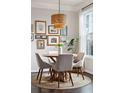 Charming dining area featuring a round wooden table, neutral chairs, and an artistic gallery wall at 2022 Chatelain Way, Mount Pleasant, SC 29464