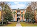 Exterior view of a colorful apartment building with palm trees and well-maintained landscaping at 2022 Chatelain Way, Mount Pleasant, SC 29464
