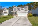 Inviting two-story home featuring a concrete driveway, attached two-car garage, and landscaped front yard at 206 Woodbrook Way, Moncks Corner, SC 29461