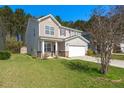 Two-story home with tidy lawn and two-car garage, complemented by mature trees and a shed at 206 Woodbrook Way, Moncks Corner, SC 29461