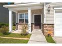 A welcoming front porch with brick accents and white columns, leading to the front door at 206 Woodbrook Way, Moncks Corner, SC 29461
