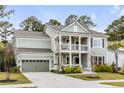 Charming two-story home featuring a double porch, attached garage, and landscaped yard at 2335 Brinkley Rd, Johns Island, SC 29455