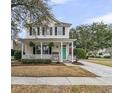 Charming home featuring a welcoming front porch, a lovely green door, and professionally landscaped yard at 2369 Chadbury Ln, Mount Pleasant, SC 29466
