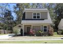 Close up of a charming two-story home with a red door and landscaped front yard at 263 Stefan Dr, Charleston, SC 29412